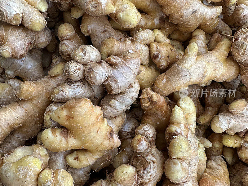 新鲜农产品市场成堆的姜根(Zingiber officinale)的全帧图像，高架视图